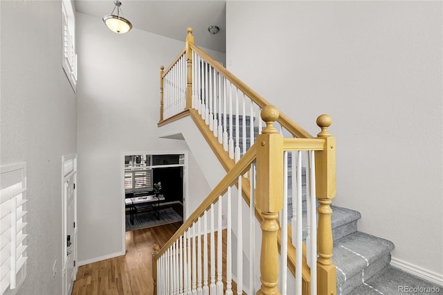 3406 Purcell St, Brighton, CO 80601 - stairs featuring wood finished floors, a towering ceiling, and baseboards