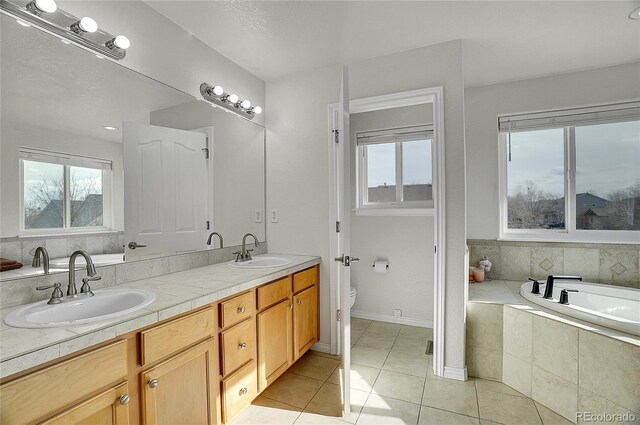 3406 Purcell St, Brighton, CO 80601 - full bath featuring toilet, tile patterned flooring, tiled bath, and double vanity