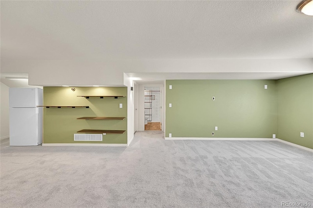 3406 Purcell St, Brighton, CO 80601 - finished below grade area featuring freestanding refrigerator, carpet, baseboards, and a textured ceiling