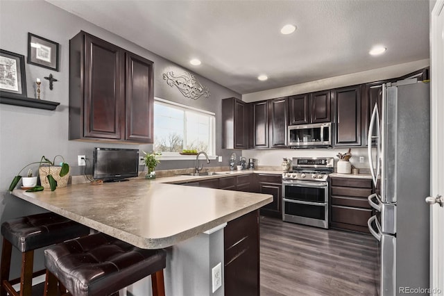 23757 Eagle Bend Ln, Parker, CO 80138 - kitchen featuring stainless steel appliances, a sink, a peninsula, light countertops, and dark brown cabinets