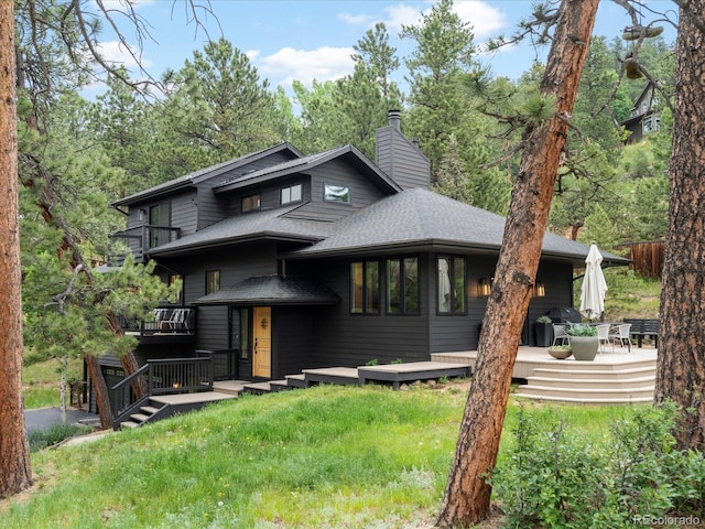 28833 Western Dr, Evergreen, CO 80439 - view of front of home with a chimney, a shingled roof, a balcony, and a deck