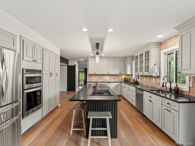 28833 Western Dr, Evergreen, CO 80439 - kitchen with stainless steel appliances, a barn door, a kitchen breakfast bar, backsplash, and a kitchen island