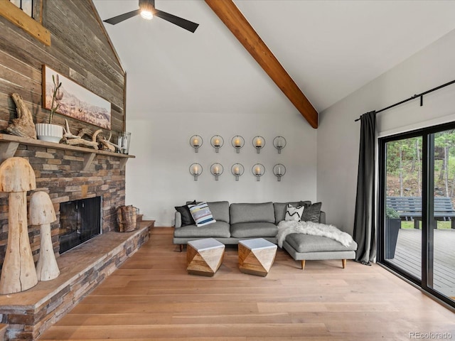 28833 Western Dr, Evergreen, CO 80439 - living area with a ceiling fan, wood finished floors, beam ceiling, high vaulted ceiling, and a stone fireplace
