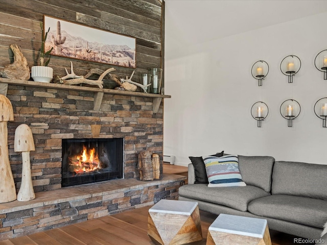 28833 Western Dr, Evergreen, CO 80439 - living area with wood finished floors, a baseboard radiator, and a stone fireplace