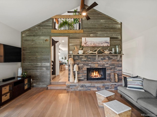 28833 Western Dr, Evergreen, CO 80439 - living area with hardwood / wood-style flooring, a ceiling fan, a stone fireplace, high vaulted ceiling, and a baseboard heating unit