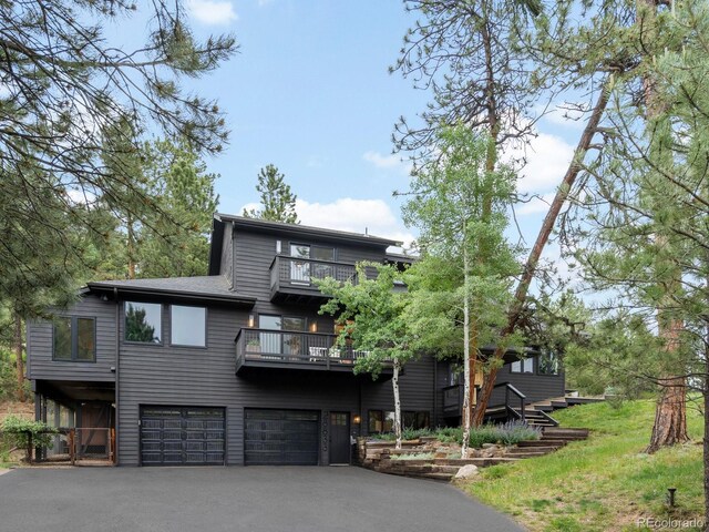 28833 Western Dr, Evergreen, CO 80439 - view of front of house featuring a balcony, an attached garage, and asphalt driveway
