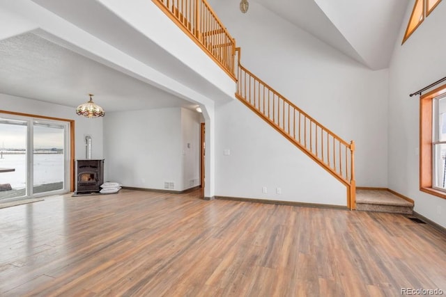 unfurnished living room with hardwood / wood-style flooring and a wood stove