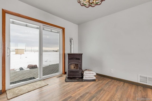 interior space featuring hardwood / wood-style floors, a wealth of natural light, and a wood stove