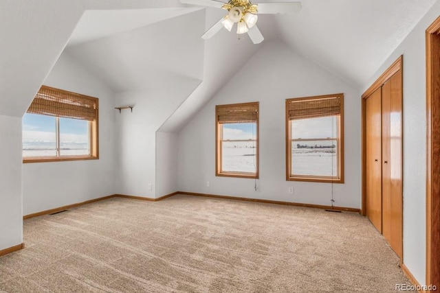 additional living space featuring light carpet, lofted ceiling, and ceiling fan