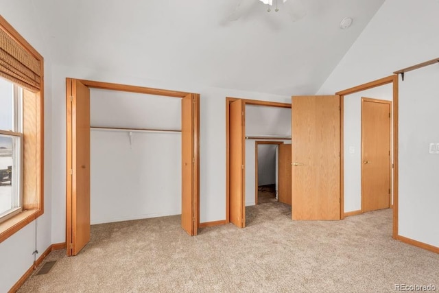 unfurnished bedroom featuring light carpet, vaulted ceiling, and ceiling fan