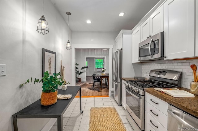 3002 Quitman St, Denver, CO 80212 - kitchen with stainless steel appliances, white cabinets, decorative backsplash, light tile patterned floors, and pendant lighting