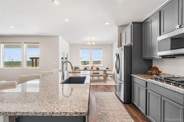 kitchen featuring a sink, stainless steel appliances, dark wood-type flooring, a chandelier, and gray cabinetry