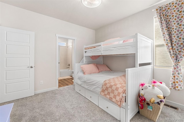bedroom featuring ensuite bathroom, carpet, baseboards, and multiple windows