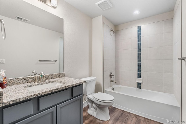 bathroom featuring toilet, visible vents, wood finished floors, and vanity