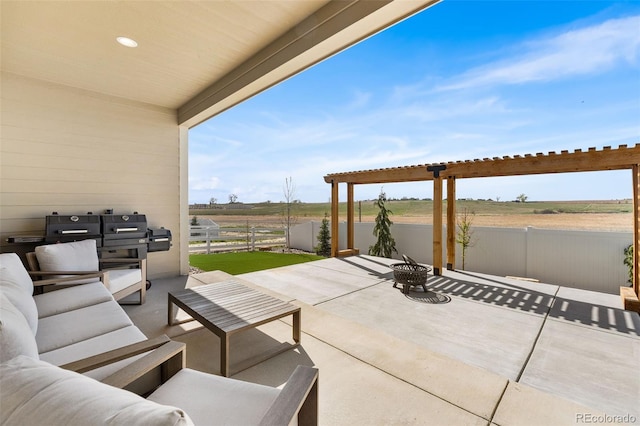 view of patio / terrace with a rural view, fence, and an outdoor living space