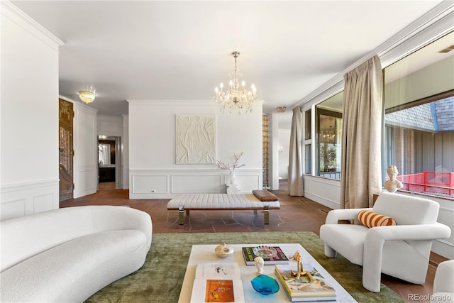 living room featuring a chandelier, a decorative wall, a wainscoted wall, and ornamental molding