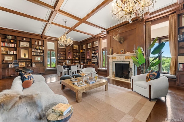 living room featuring hardwood / wood-style floors, a high end fireplace, coffered ceiling, beamed ceiling, and a chandelier