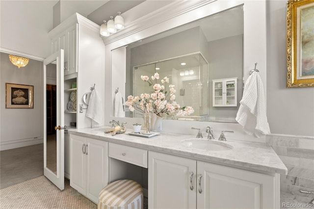 bathroom featuring a sink, an enclosed shower, and double vanity