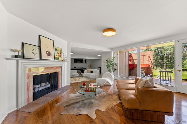 living room featuring a tile fireplace and wood-type flooring