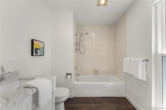 full bathroom featuring washtub / shower combination, toilet, baseboards, and wood finished floors