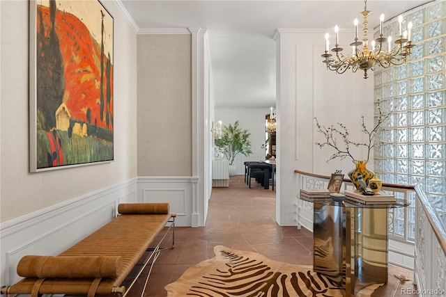 hallway featuring tile patterned floors, ornamental molding, and an inviting chandelier