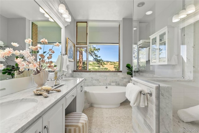 bathroom featuring tile patterned flooring, vanity, tile walls, and a bathing tub