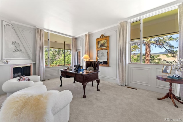 office featuring visible vents, light carpet, a fireplace, and a decorative wall