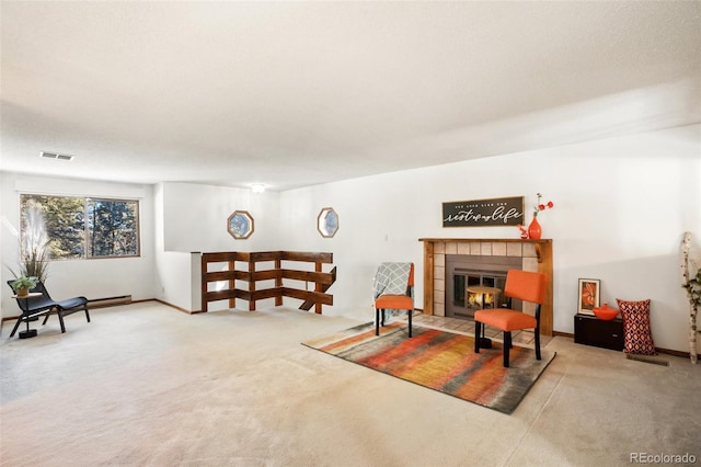 living room featuring visible vents, carpet floors, baseboards, and a tile fireplace
