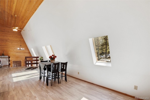 dining room featuring wooden walls, a ceiling fan, high vaulted ceiling, wooden ceiling, and light wood-type flooring