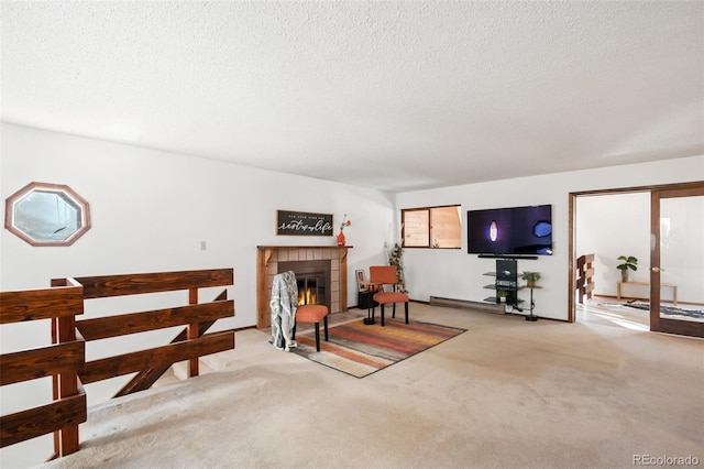 living area featuring carpet floors, a textured ceiling, and a glass covered fireplace