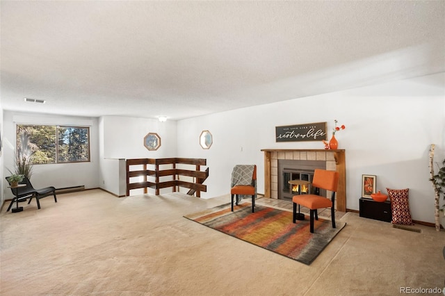 sitting room featuring carpet flooring, a fireplace, a textured ceiling, and visible vents