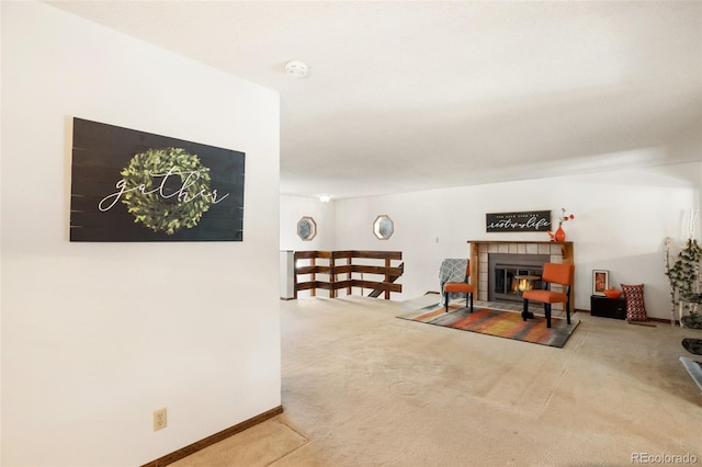 living room with a tiled fireplace, baseboards, and carpet