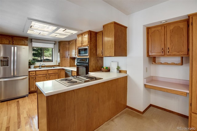 kitchen with baseboards, light countertops, a peninsula, brown cabinetry, and stainless steel appliances