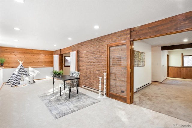 interior space featuring beamed ceiling, brick wall, baseboard heating, and carpet floors