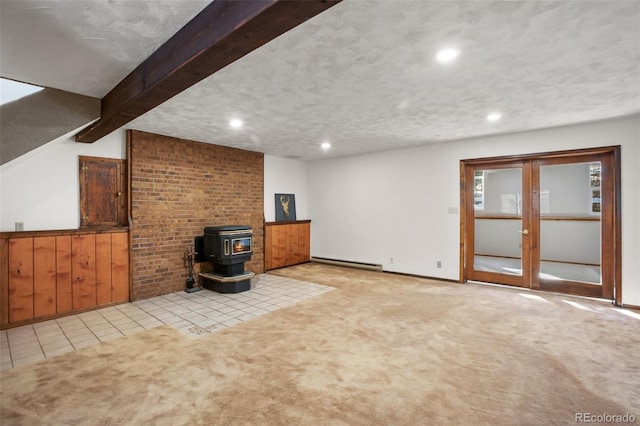 unfurnished living room featuring beam ceiling, light colored carpet, a baseboard heating unit, and a wood stove