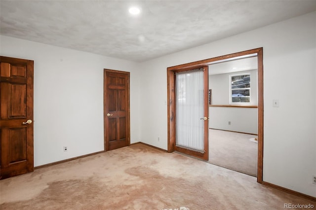 spare room featuring light carpet, recessed lighting, and baseboards