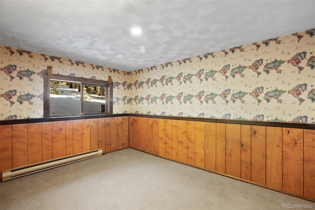 carpeted spare room with baseboard heating, wainscoting, and wallpapered walls