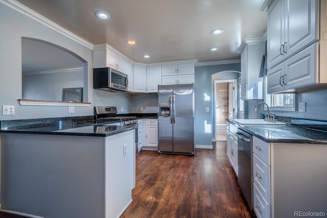 kitchen with stainless steel appliances, white cabinets, and ornamental molding