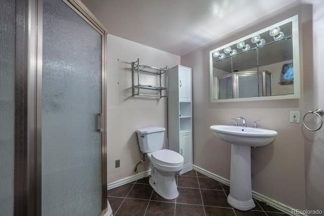 full bathroom with a stall shower, tile patterned flooring, toilet, and baseboards