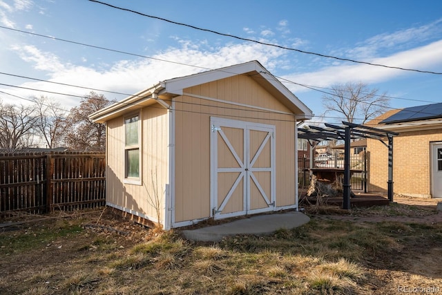 view of shed with fence and a pergola