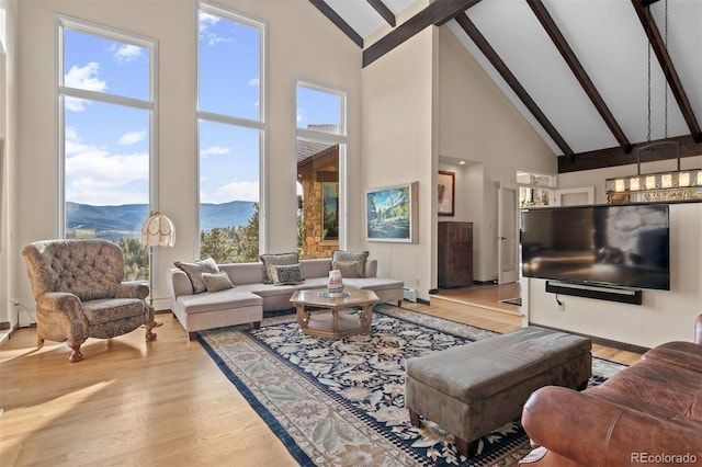 living room with light hardwood / wood-style flooring, high vaulted ceiling, and beamed ceiling