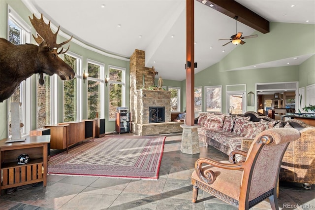 living room featuring ceiling fan, a stone fireplace, high vaulted ceiling, and beam ceiling