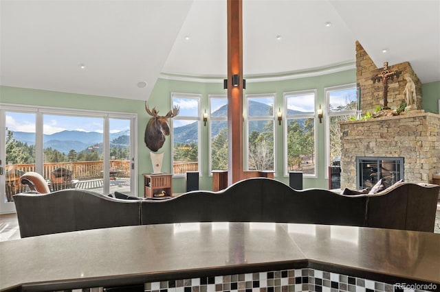 unfurnished sunroom with lofted ceiling, a fireplace, and a mountain view