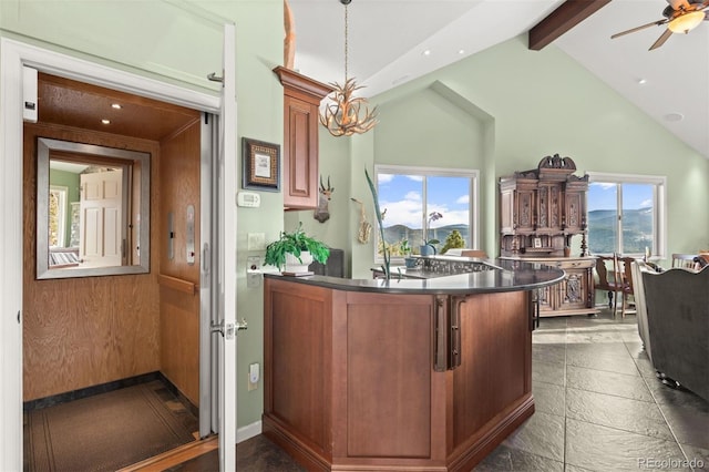 kitchen featuring beam ceiling, a wealth of natural light, decorative light fixtures, and ceiling fan