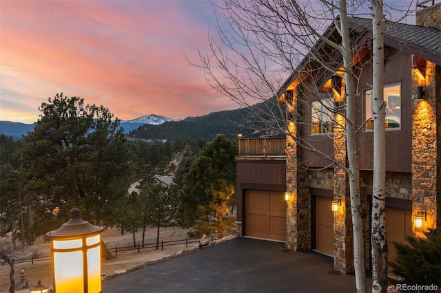 view of front of property featuring a mountain view, a garage, and a balcony