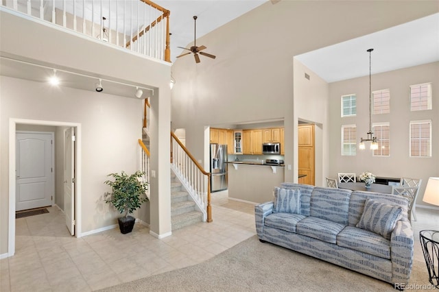 living room featuring ceiling fan, a towering ceiling, and light tile patterned flooring