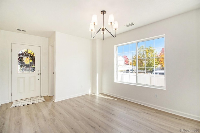 unfurnished dining area featuring light hardwood / wood-style flooring and a chandelier