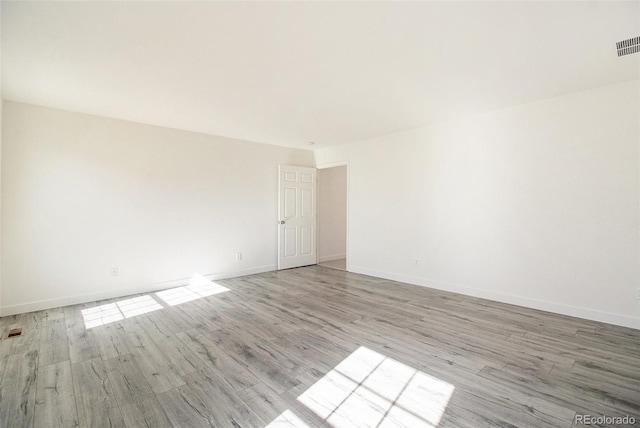 empty room with light hardwood / wood-style flooring