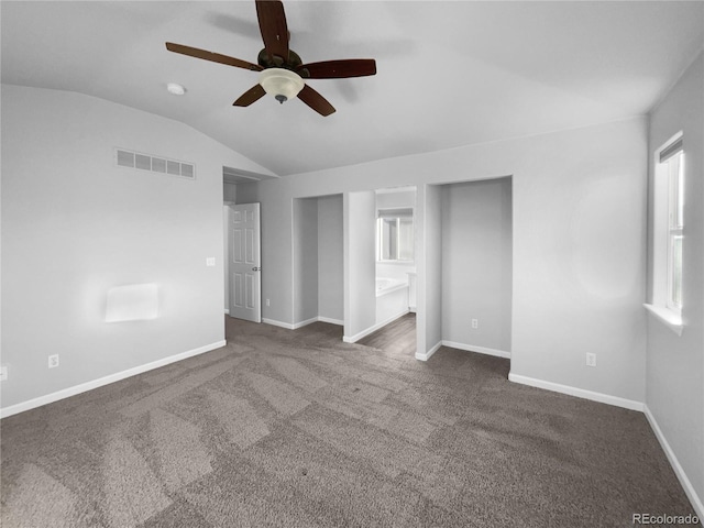 spare room with ceiling fan, dark carpet, and lofted ceiling