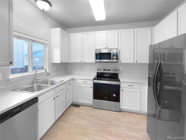 kitchen featuring sink, white cabinets, stainless steel appliances, and light hardwood / wood-style flooring